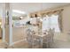 Open-concept dining area with white furniture and large window offering natural light and kitchen view at 9147 Rhett Ln, Weeki Wachee, FL 34613