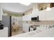 Bright kitchen with white cabinets, appliances, and views to an adjacent breakfast nook at 9147 Rhett Ln, Weeki Wachee, FL 34613