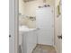 Functional laundry area equipped with washer, dryer, storage shelf, and easy access to outdoors at 9147 Rhett Ln, Weeki Wachee, FL 34613