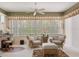 Cozy living area featuring wicker chairs, a ceiling fan, and large windows with backyard views at 9147 Rhett Ln, Weeki Wachee, FL 34613
