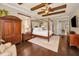 Spacious main bedroom with ceiling fan, hardwood floors, and a four-poster bed at 10019 Milano Dr, Trinity, FL 34655