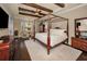 Elegant main bedroom suite featuring a four-poster bed, sitting area, and hardwood floors at 10019 Milano Dr, Trinity, FL 34655