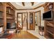 Office with built-in bookshelves and media, and an open view to the entry and stairway at 10019 Milano Dr, Trinity, FL 34655
