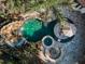 Aerial shot of backyard oasis with custom pool, spa, rock waterfall and slide, surrounded by lush landscaping at 10019 Milano Dr, Trinity, FL 34655
