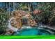 A lagoon style pool with waterfalls, slide, fire pit and plenty of palms in a private backyard setting at 10019 Milano Dr, Trinity, FL 34655