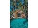 Stunning swimming pool with a large rock waterfall and water slide surrounded by tropical greenery at 10019 Milano Dr, Trinity, FL 34655