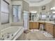 Bright bathroom boasts a soaking tub, glass shower, and double vanities with ample counter space at 10109 Holly Berry Dr, Spring Hill, FL 34613