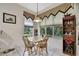 Charming dining area features a wooden table, decorative lighting, and views of the landscaped yard at 10109 Holly Berry Dr, Spring Hill, FL 34613