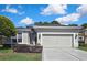 Charming home featuring a well-manicured front yard, a concrete driveway, and a spacious two-car attached garage at 10109 Holly Berry Dr, Spring Hill, FL 34613
