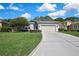 Charming single-story home boasts a well-manicured lawn and an attached two-car garage with a concrete driveway at 10109 Holly Berry Dr, Spring Hill, FL 34613