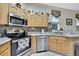 Bright kitchen boasts stainless steel appliances, wood cabinets, and a decorative tile backsplash at 10109 Holly Berry Dr, Spring Hill, FL 34613
