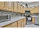 Well-appointed kitchen features light wood cabinets, granite countertops, stainless steel appliances, and a tile backsplash at 10109 Holly Berry Dr, Spring Hill, FL 34613