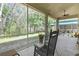 Screened in porch overlooking wooded area and featuring a ceiling fan at 10109 Holly Berry Dr, Spring Hill, FL 34613