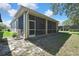 View of the screened-in porch with access door and fan, surrounded by a well-maintained lawn and landscape at 10109 Holly Berry Dr, Spring Hill, FL 34613