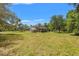 Expansive backyard with lush greenery, covered patio, and greenhouse offers plenty of space for outdoor activities at 10645 Fawn Dr, New Port Richey, FL 34654