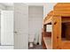 View into a bathroom off the storage room with a standard toilet, with wooden shelving in the foreground at 10645 Fawn Dr, New Port Richey, FL 34654