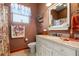 Bathroom with a granite countertop vanity, decorative mirror, and floral-themed accents at 10645 Fawn Dr, New Port Richey, FL 34654
