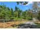 View of the long driveway leading to the home, lined by fencing and mature trees, enhancing the sense of privacy at 10645 Fawn Dr, New Port Richey, FL 34654