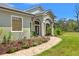 Elegant single-story home showcasing decorative stone walkway leading to the entrance, and vibrant flower beds at 10645 Fawn Dr, New Port Richey, FL 34654