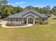 Charming single-story home featuring manicured landscaping, mature trees, and a welcoming entrance with columns at 10645 Fawn Dr, New Port Richey, FL 34654