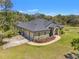 Exterior of the house featuring a gray roof, landscaping, and ample parking with a spacious three car garage at 10645 Fawn Dr, New Port Richey, FL 34654