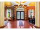 Spacious foyer showcasing hard wood floors, decorative columns, chandelier, and views into the dining and living areas at 10645 Fawn Dr, New Port Richey, FL 34654