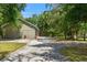 View of the detached three-car garage exterior, showing driveway and landscaping at 10645 Fawn Dr, New Port Richey, FL 34654