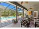 Enclosed patio with ceiling fan, dart board, outdoor seating area, and screened-in pool at 10645 Fawn Dr, New Port Richey, FL 34654
