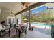 Outdoor seating area on the covered patio with a ceiling fan and screened-in pool at 10645 Fawn Dr, New Port Richey, FL 34654