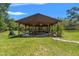 Backyard pavilion featuring a picnic table, overhead lighting, and well-manicured lawn at 10645 Fawn Dr, New Port Richey, FL 34654