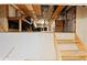 View of the unfinished attic with exposed insulation and plywood flooring, with access from wooden stairs at 10645 Fawn Dr, New Port Richey, FL 34654