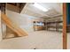 View of the unfinished attic with exposed insulation, unfinished drywall, wooden shelving, and plywood flooring at 10645 Fawn Dr, New Port Richey, FL 34654