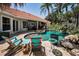 Charming backyard oasis featuring a refreshing pool, and colorful Adirondack chairs for relaxing outdoors at 10712 Pontofino Cir, Trinity, FL 34655