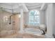 Bright bathroom featuring a glass shower, large soaking tub, and natural light at 10712 Pontofino Cir, Trinity, FL 34655
