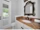 Powder room with a stone countertop and unique mirror with outdoor access at 10712 Pontofino Cir, Trinity, FL 34655