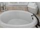 Close up of an oval soaking tub, and folded towels in a light and airy bathroom at 10712 Pontofino Cir, Trinity, FL 34655