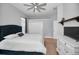 Bright bedroom with modern ceiling fan, wood floors, and closet for ample storage at 10712 Pontofino Cir, Trinity, FL 34655