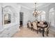 Formal dining room with elegant chandelier, wainscoting, and views to the entryway at 10712 Pontofino Cir, Trinity, FL 34655