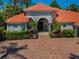 Charming home with a clay tile roof, a brick paver driveway and mature, lush landscaping at 10712 Pontofino Cir, Trinity, FL 34655