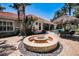 A gorgeous fire pit surrounded by lush landscaping, with seating and sun shade, perfect for outdoor entertaining and relaxation at 10712 Pontofino Cir, Trinity, FL 34655