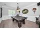 A bright game room features a dark wood ping pong table, hardwood floors and elegant decor at 10712 Pontofino Cir, Trinity, FL 34655