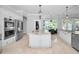 Gourmet kitchen features stainless steel appliances, a center island with a sink, and custom white cabinetry at 10712 Pontofino Cir, Trinity, FL 34655