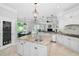 Gourmet kitchen with granite countertops, a center island, custom cabinets, and access to the outdoor dining area at 10712 Pontofino Cir, Trinity, FL 34655