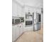 Kitchen features stainless steel appliances, custom white cabinets, and granite countertops at 10712 Pontofino Cir, Trinity, FL 34655