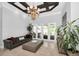 Elegant living room featuring coffered ceilings, modern chandelier, and access to the outdoor living space at 10712 Pontofino Cir, Trinity, FL 34655