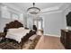 Bright main bedroom with hardwood floors, a chandelier, and a carved wood bed frame at 10712 Pontofino Cir, Trinity, FL 34655
