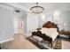 Main bedroom featuring hardwood floors, a crystal chandelier, and an en-suite bathroom at 10712 Pontofino Cir, Trinity, FL 34655
