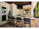 Outdoor kitchen featuring a stone countertop, sink, and bar seating for entertaining at 10712 Pontofino Cir, Trinity, FL 34655