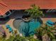 Aerial view of a private pool surrounded by brick pavers, palm trees and comfortable lounge chairs at 10712 Pontofino Cir, Trinity, FL 34655