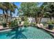 Inviting lagoon style pool, surrounded by lush tropical landscaping and rock features, creating a serene backyard oasis at 10712 Pontofino Cir, Trinity, FL 34655